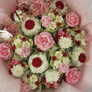 Bouquet of intricately crafted pink and white flower cupcakes.
