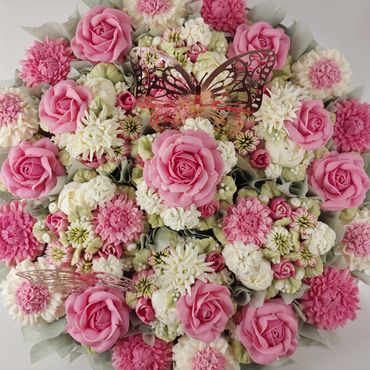 A bouquet of pink and white flowers with decorative butterflies.