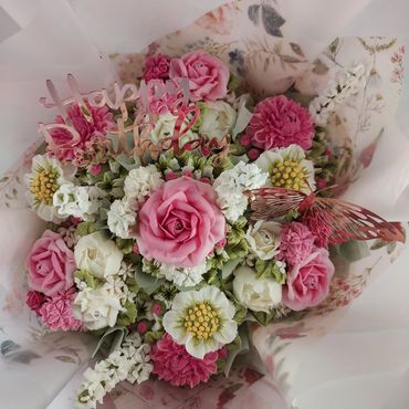 Elegant birthday bouquet with pink and white flowers and a butterfly decoration.