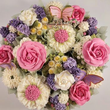 A beautiful bouquet of pastel flowers with a decorative key and butterflies.