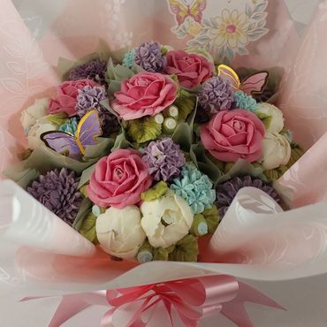 A vibrant bouquet of pink, purple, and white flowers with butterfly decorations.