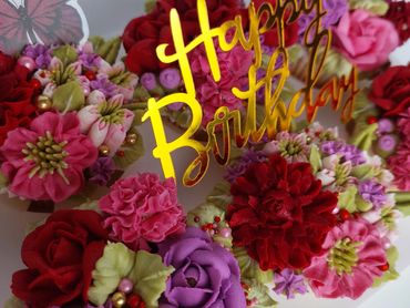 Colorful floral arrangement with a golden Happy Birthday sign.