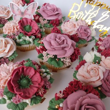 Cupcakes decorated with beautiful floral frosting and a butterfly topper.