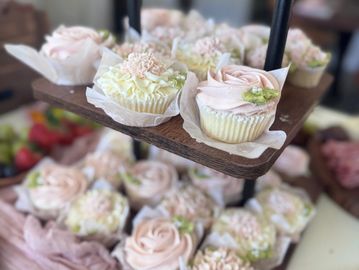 Elegant cupcakes decorated with pastel-colored frosting and delicate flowers.