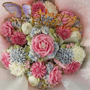 A colorful birthday bouquet with pink, white, and purple flowers and a butterfly decoration.