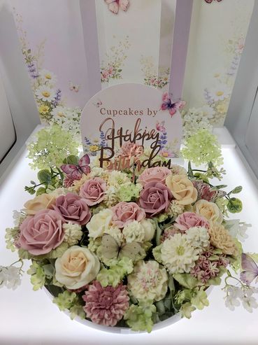 A beautiful floral birthday arrangement with pastel roses and butterflies.