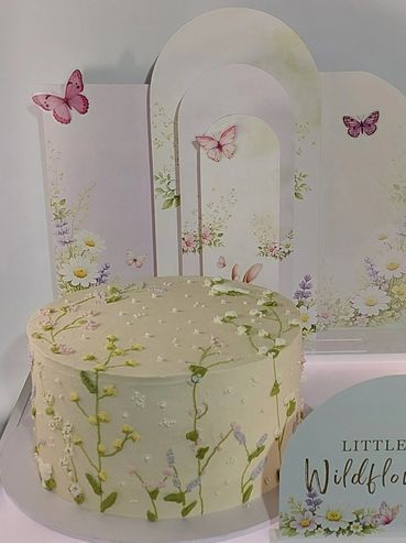 Elegant cake with delicate wildflower and butterfly decorations.