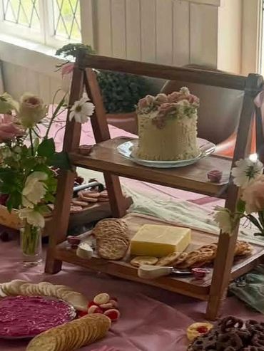 Elegant cake and snacks on a wooden stand.