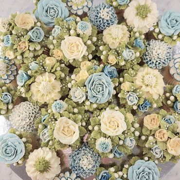 Elegant combination of floral buttercream cupcakes arranged on a platter board