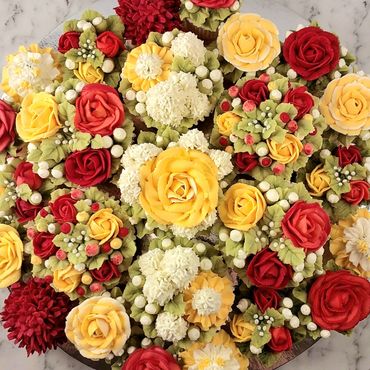 Elegant combination of floral buttercream cupcakes arranged on a platter board