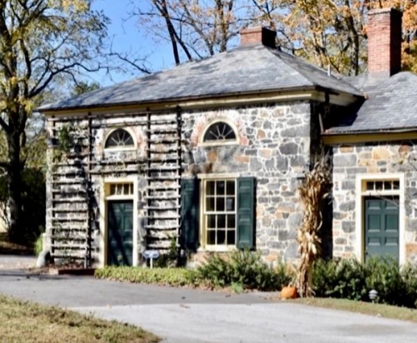 Old stone building with green doors and windows.