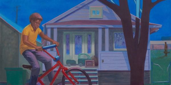 Boy riding a bike in front of a house at dusk.