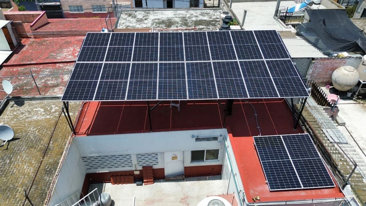 Solar panels installed on a rooftop in an urban area.