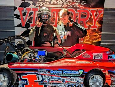 Two individuals celebrate a go-kart victory at Fremont Raceway Victory Park.