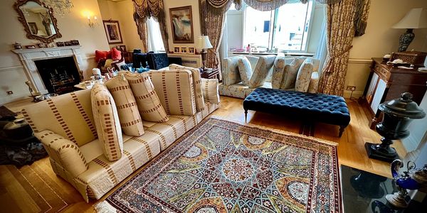 A three-seater fabric sofa and ottoman are cleaned in an apartment in Fulham.