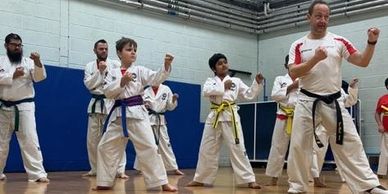 taekwondo students practising patterns with instructor.