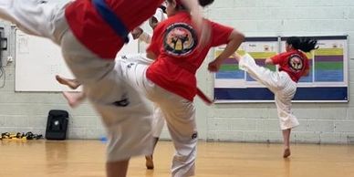 taekwondo students demonstrating jumping side kicks