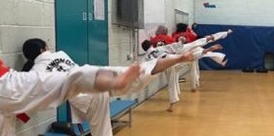 students practising side kick flexibility and strength training
