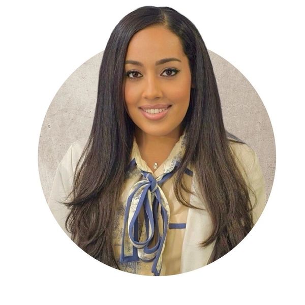 Professional woman with long dark hair smiling.
