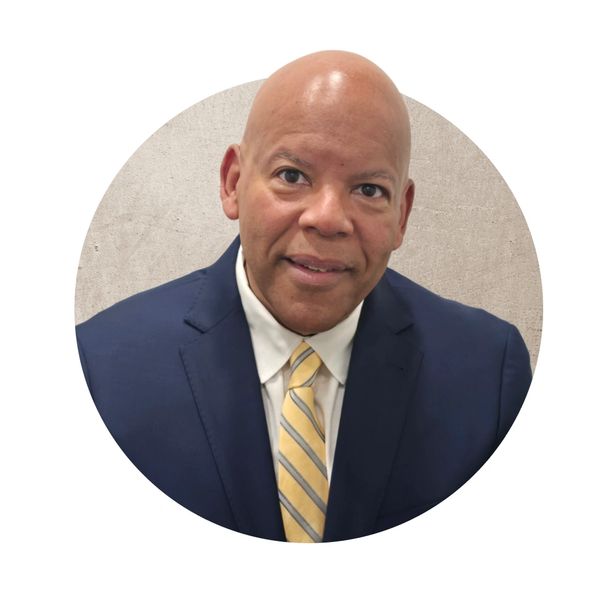 Professional man in navy suit and yellow striped tie.