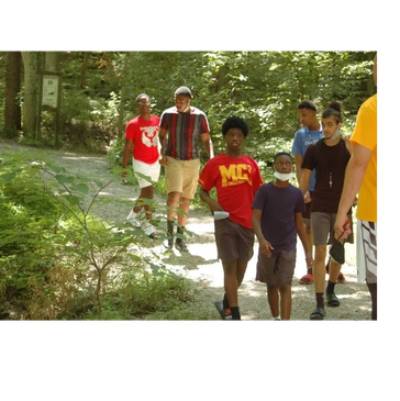 Group of boys walking on a forest trail on a sunny day.