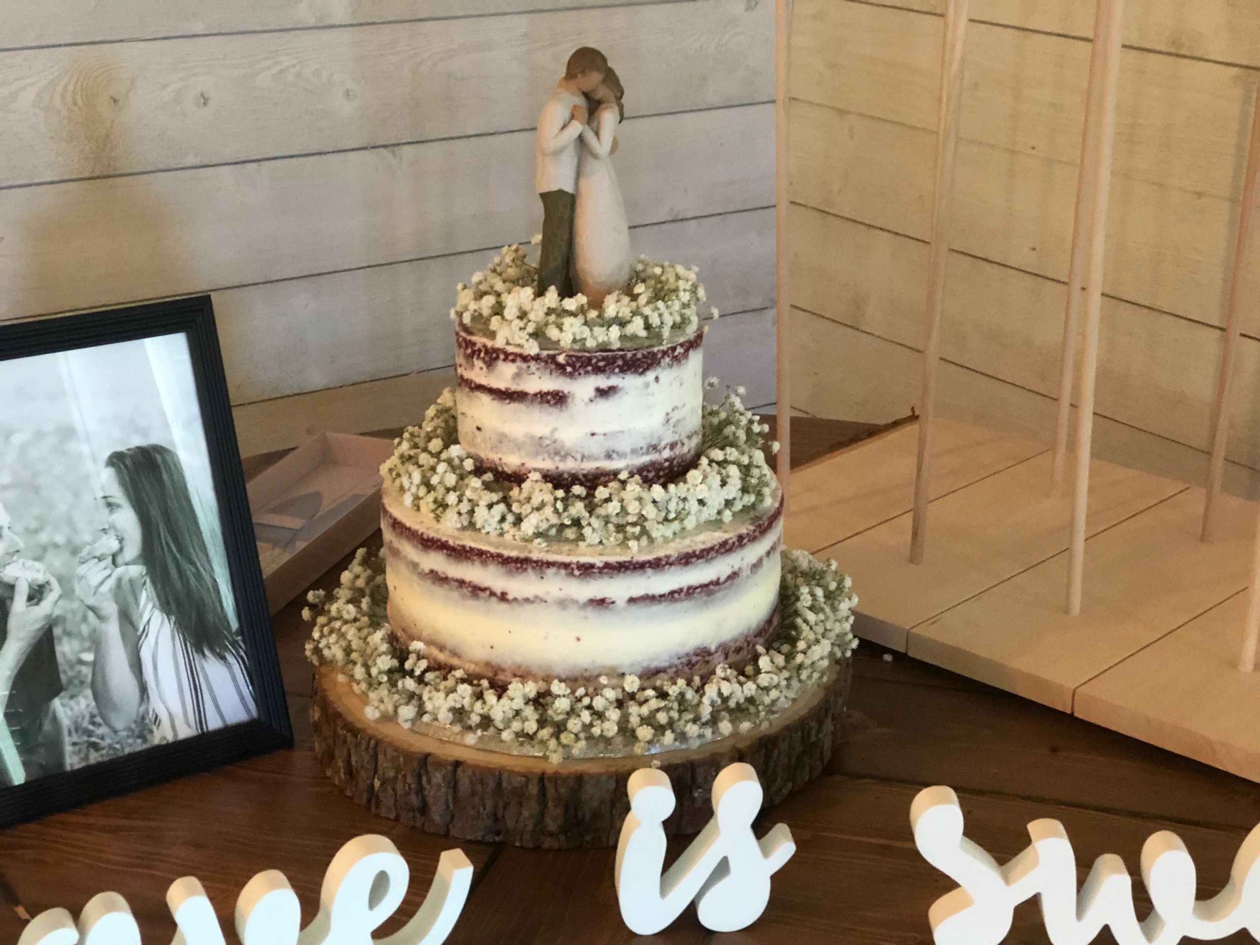 Rustic wedding cake with bride and groom figurine.