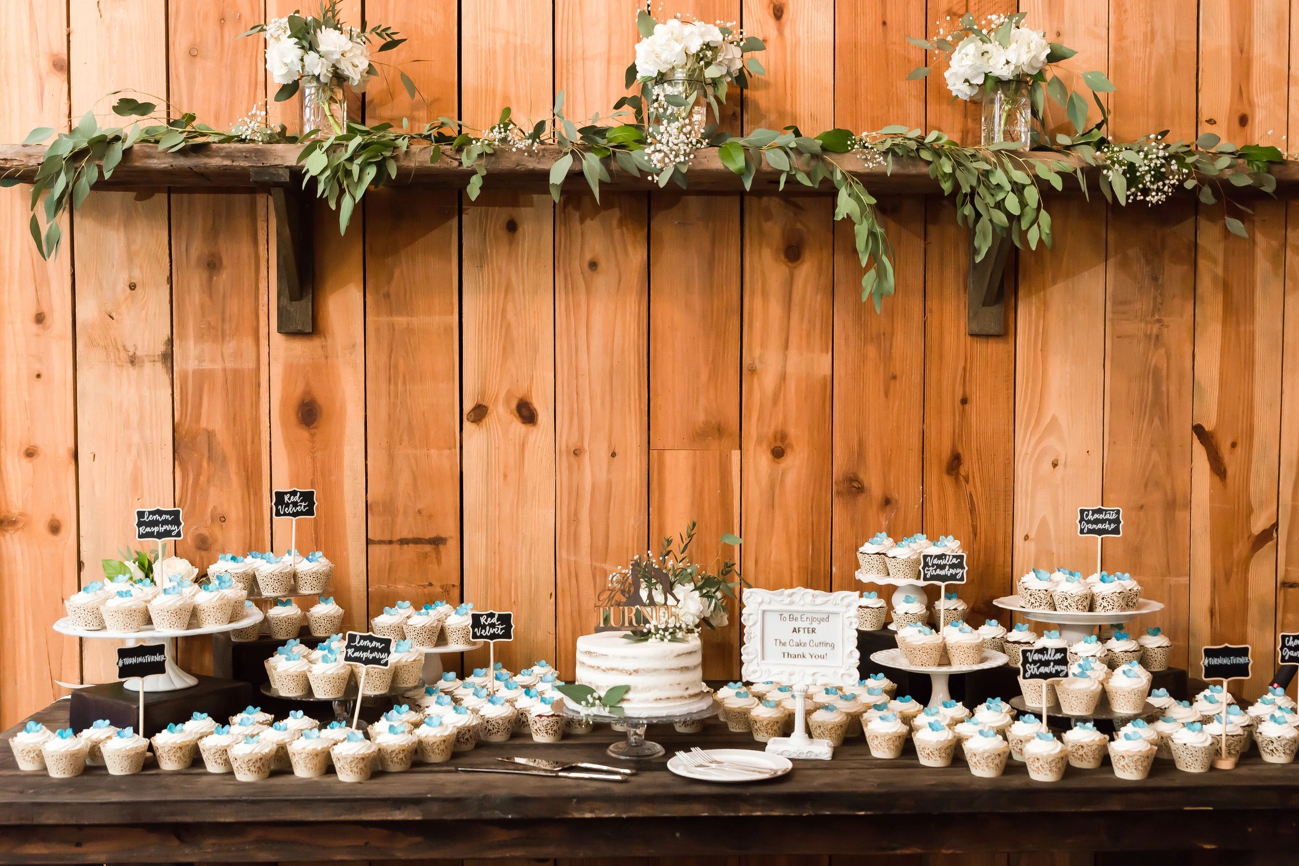 Wedding dessert table with cupcakes and flowers.