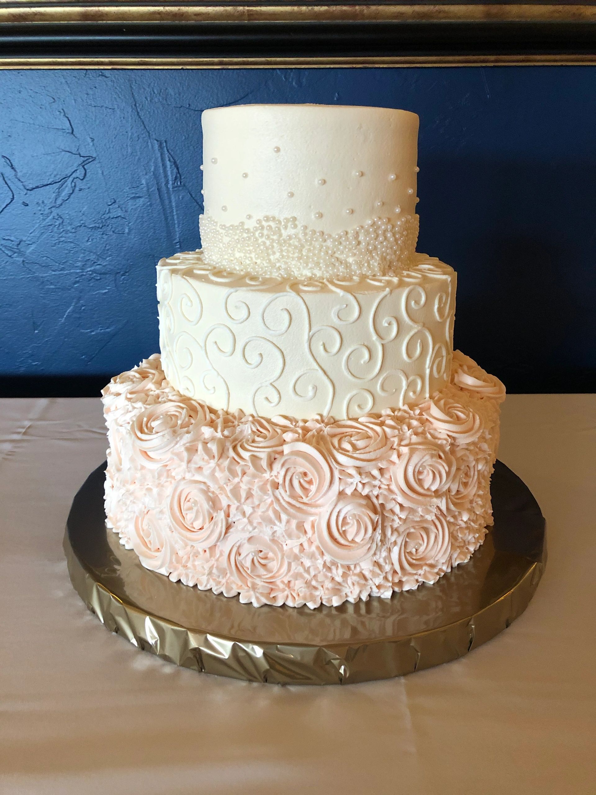 Elegant three-tiered wedding cake with intricate designs.