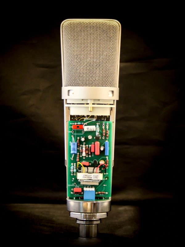 Close-up of a microphone with its internal circuit board exposed.