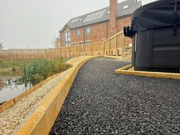 A current black resin surface in a garden before the new sand colour resin is applied.