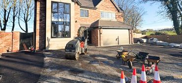 A roller on a driveway with other items waiting to prepare the surface.
