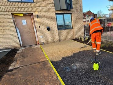 Employees racking the resin bound driveway to ensure even distribution of the resin.