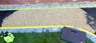A marked out pathway with lights which have been updated with sand colour resin surface.