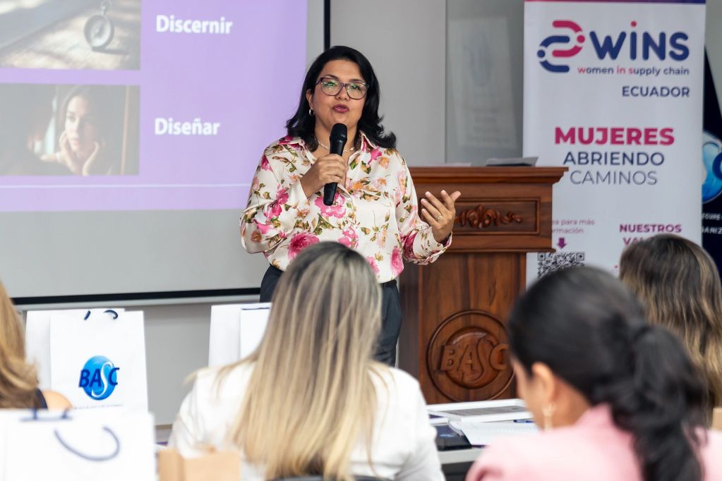 Woman speaking at a women-focused supply chain event in Ecuador.