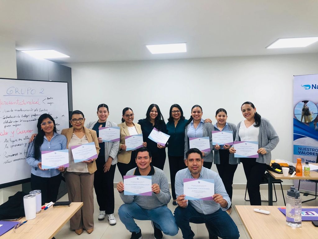 Group of professionals proudly holding certificates in an office setting.