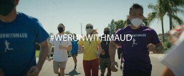 Runners wearing masks participate in a group run with #WERUNWITHMAUD.