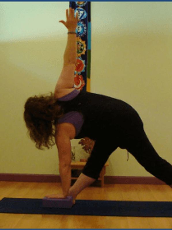 Person doing yoga with a block on a mat.