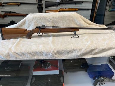 A bolt-action rifle with wooden stock displayed on a towel.