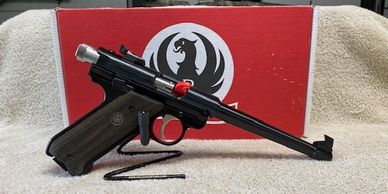 A Ruger pistol with a red trigger lock in front of a red box.