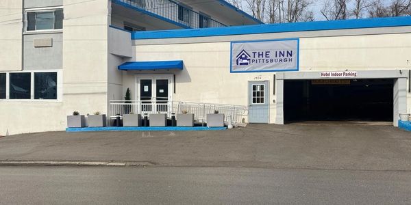 Exterior of The Inn Pittsburgh with blue accents and indoor parking.