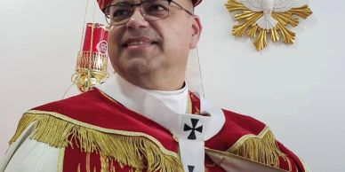 Clergyman in ornate religious attire inside a church.