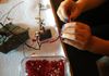 Using a third-hand device while beading a Tree of Life.