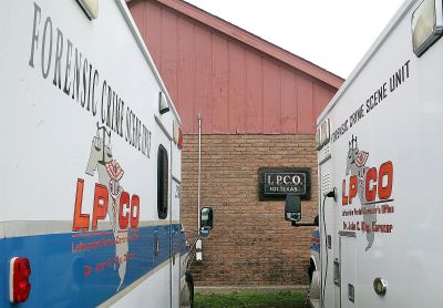 Two forensic crime scene unit vans parked close together.
