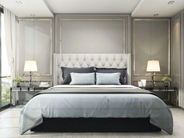 Elegant bedroom with a large bed featuring a tufted headboard and multiple pillows.