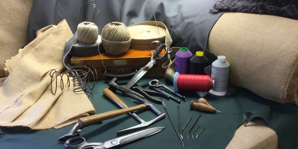A collection of tailoring tools and materials arranged on fabric.