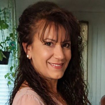 Smiling woman with curly hair indoors.