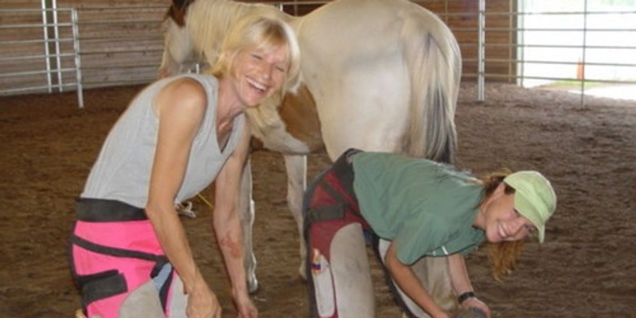 Farrier Students in the round pen laughing and smiling.