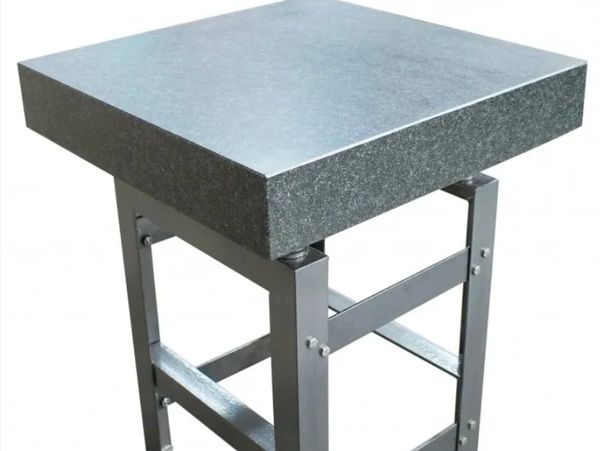 Square granite surface plate on a metal stand.