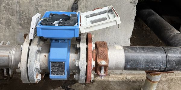 An industrial flow meter device installed on a pipe.