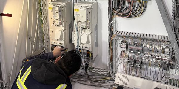 Technician working on electrical control panels.